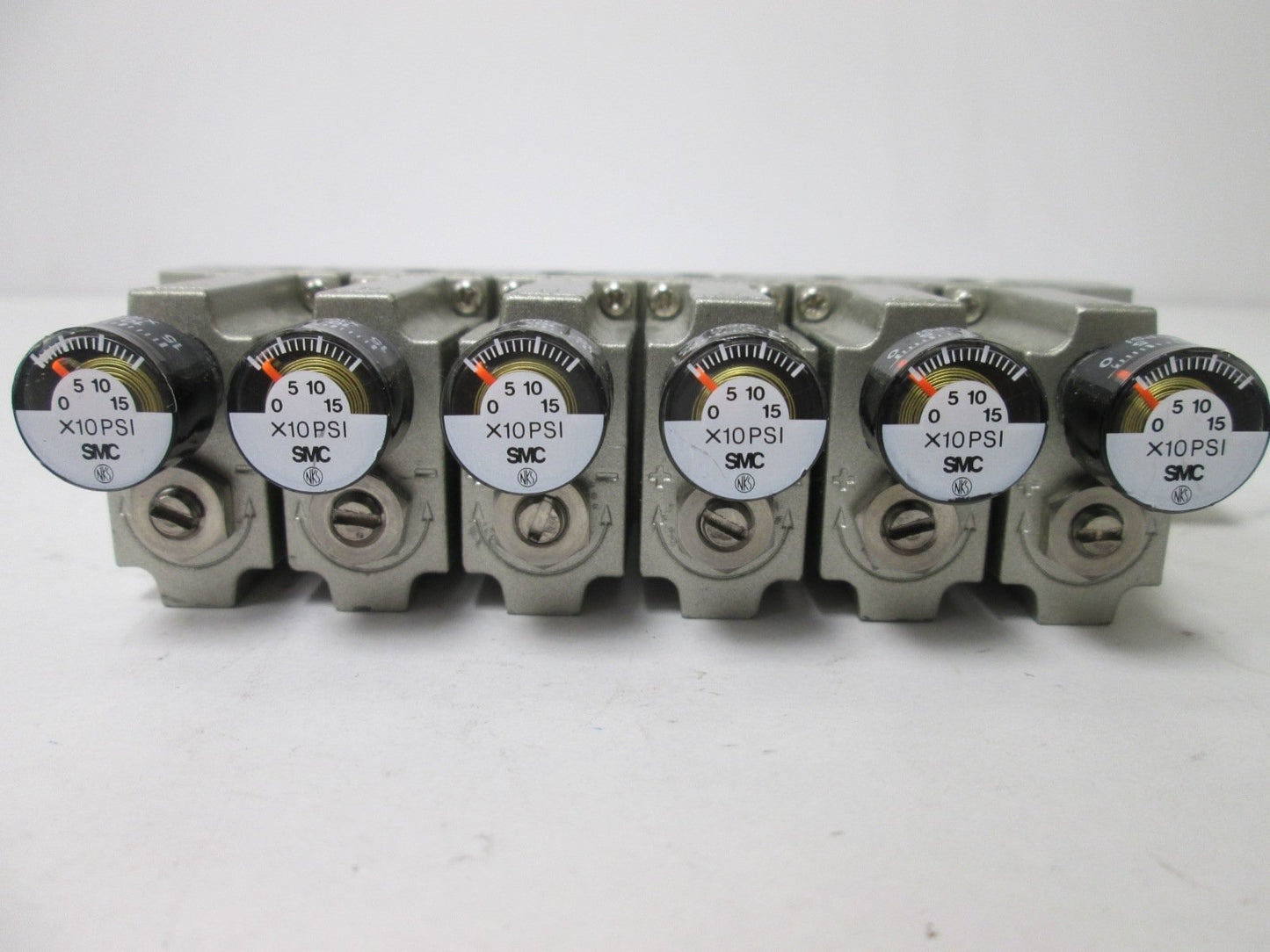 Used Bank of 6 SMC ARM1000 Manifold Regulators, With 0-150psi Gauge, 1/8" Ports